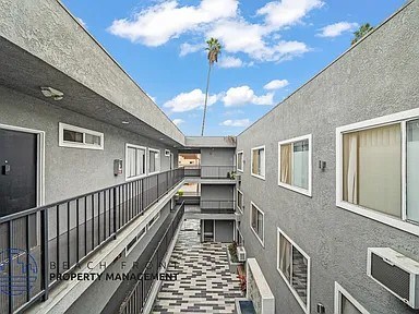 A balcony with a black railing and a tiled floor.